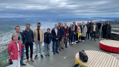 Participants at a Nordic GBD Workshop visit Mount Ulriken in Bergen, Norway. The ocean sits in the backdrop of this group photo.